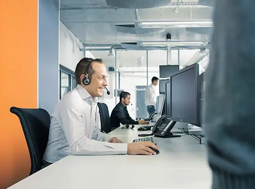Et callcenter eller kontor med støjværn, hvor en medarbejder taler i telefon