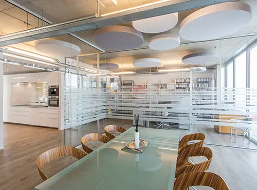 Et kontor med runde lydabsorbere til forbedring af rumakustikken.