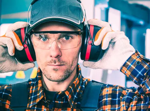 En arbejder bruger høreværn for at beskytte sig selv mod støj.