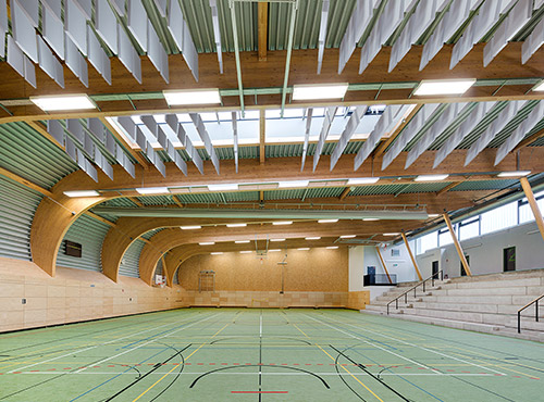 Lydabsorbere på loftet i en sportshal Fritsvævende lydabsorbere under hallens loft i en sportshal sænker støjniveauet og reducerer klang.