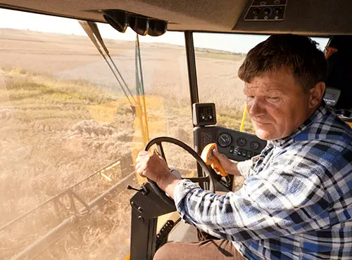 Mindre støj i landbruget - en arbejder kører i en lydisoleret mejetærsker.